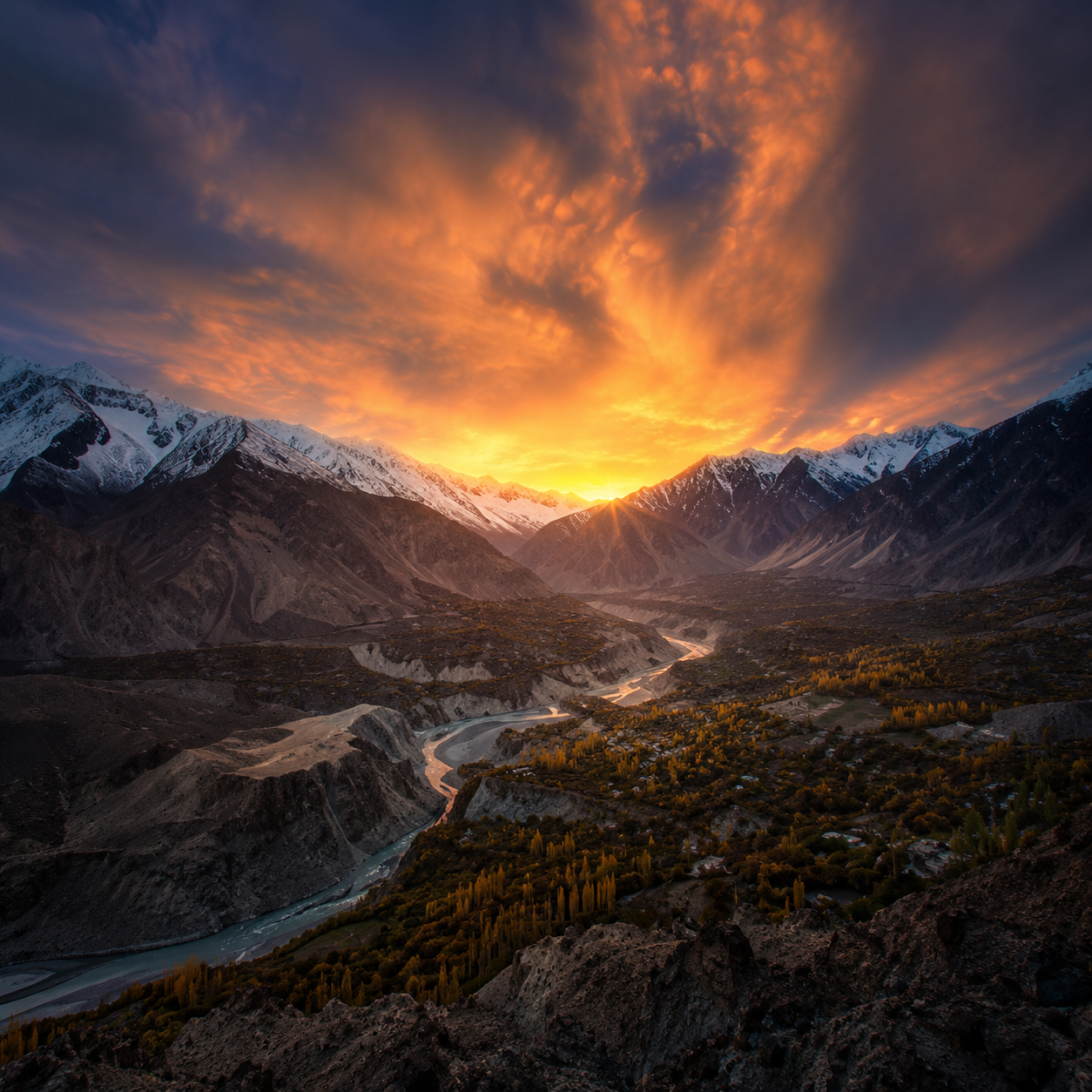 Panoramic sunset view of Hunza Valley with the winding Hunza River and Karakoram Mountains in Gilgit-Baltistan, Pakistan.
